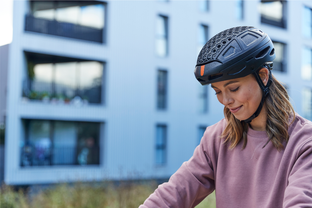 close up of woman wearing foldable bike helmet